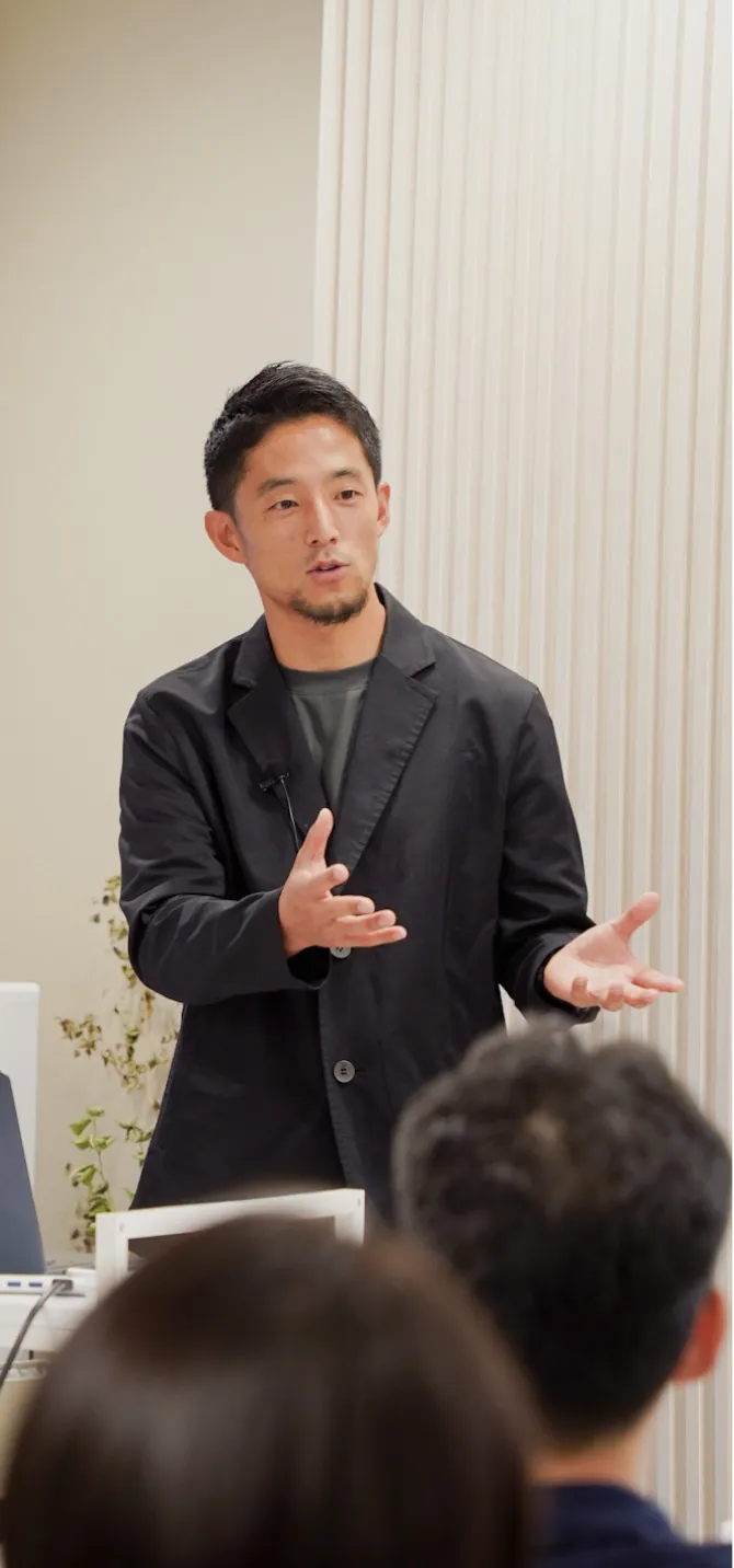 新緑の前に立つ人物の後ろ姿